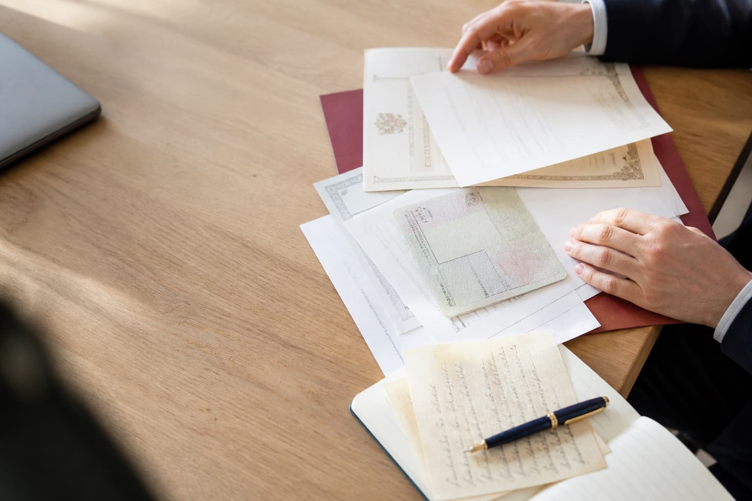Mains préparant des documents officiels pour une traduction jurée en Belgique